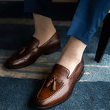Man wearing oatmeal men's dress socks and brown shoes.