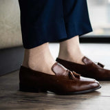 Man wearing oatmeal men's dress socks and brown shoes.