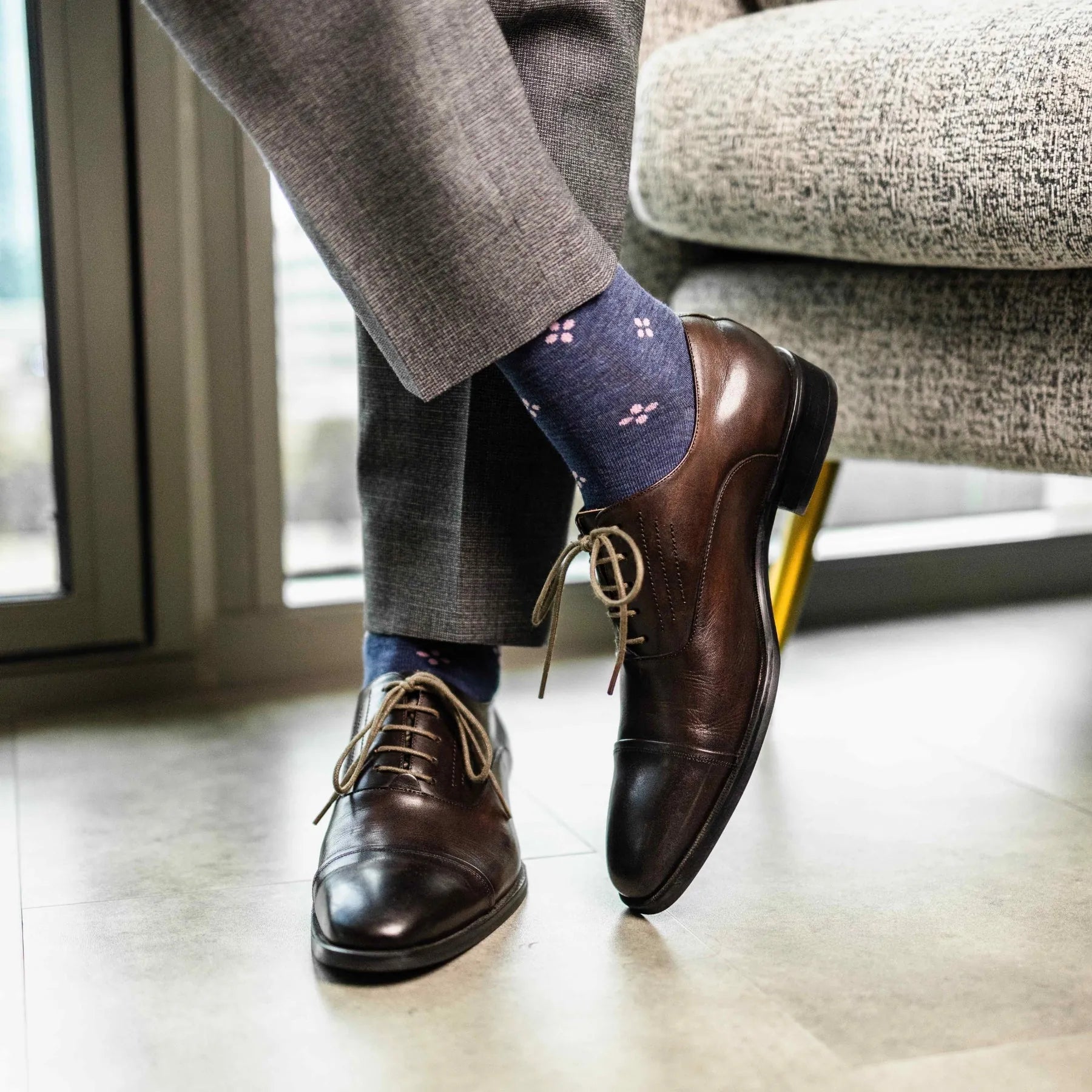 A Prussian Blue men's dress sock with a blush pink flower pattern