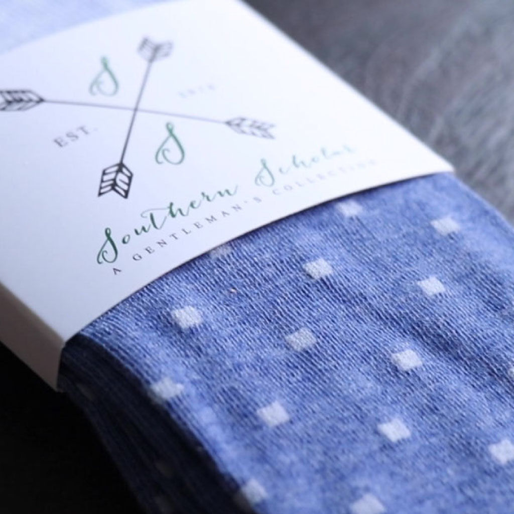 a blue pair of men's dress socks with a polka dot pattern