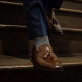 Man wearing solid, gray, and charcoal ribbed men's dress socks.