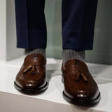 Man wearing solid, gray, and charcoal ribbed men's dress socks.