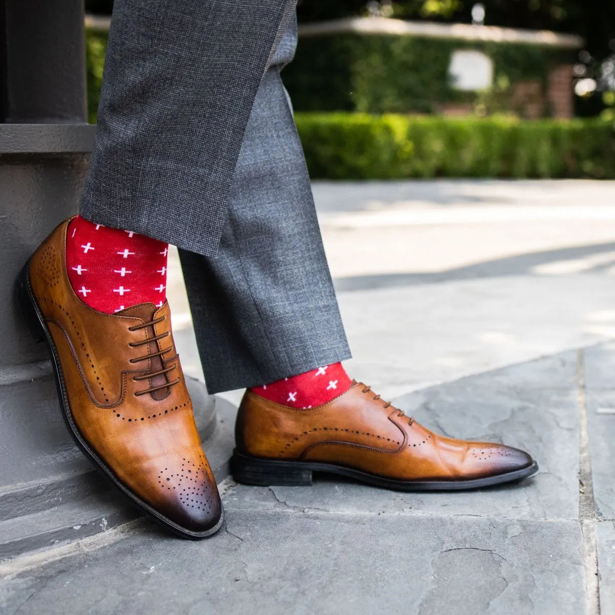 A man wearing Red socks with white hatches with grey slacks and tan shoes