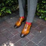 A man wearing Red socks with white hatches with grey pants
