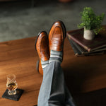 A cool men's dress sock combination of grey, sage, and olive stripes designed for refined versatility and subtle sophistication. 