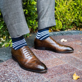 man wearing dark blue sock with white and black stripe pattern