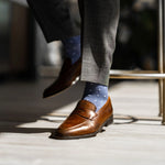 Man wearing heathered blue men's dress sock with ocean blue micro squares with grey slacks and brown shoes