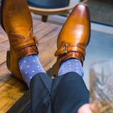 Man sitting wearing heathered blue and ocean blue micro-square socks