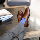 Man wearing heathered blue men's dress sock with ocean blue micro squares with grey slacks and brown shoes