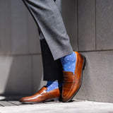 Man wearing heathered blue men's dress sock with ocean blue micro squares with grey slacks and brown shoes