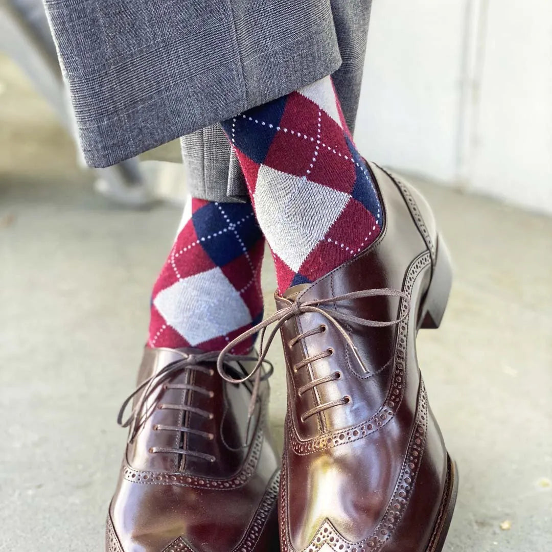 man wearing grey, red, and blue argyle socks
