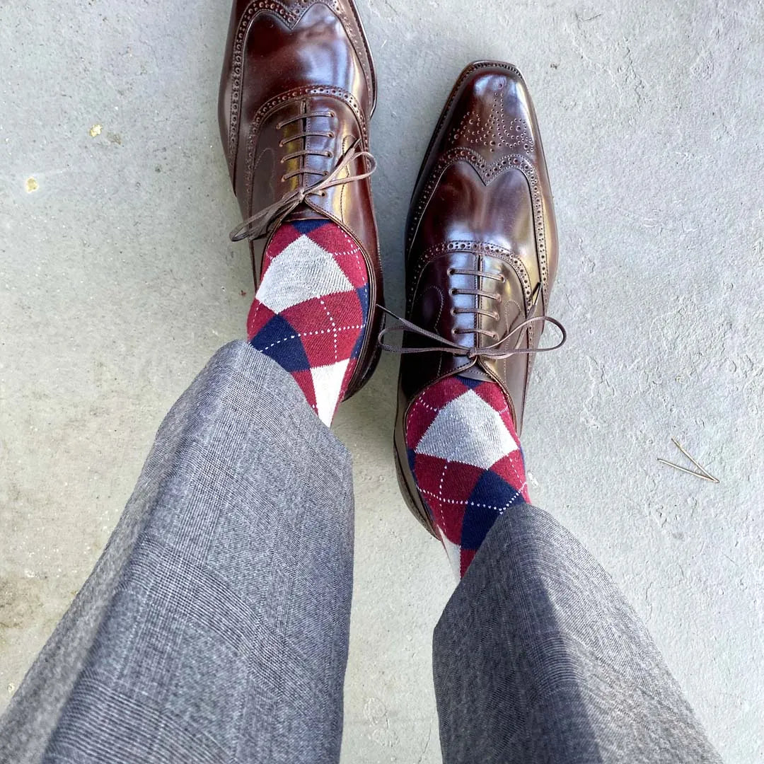 man wearing grey, red, and blue argyle socks