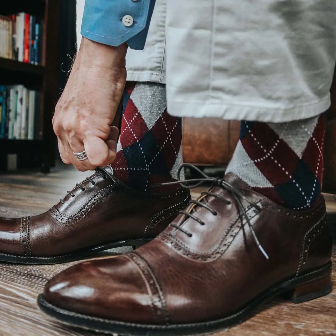 man wearing grey, red, and blue argyle socks