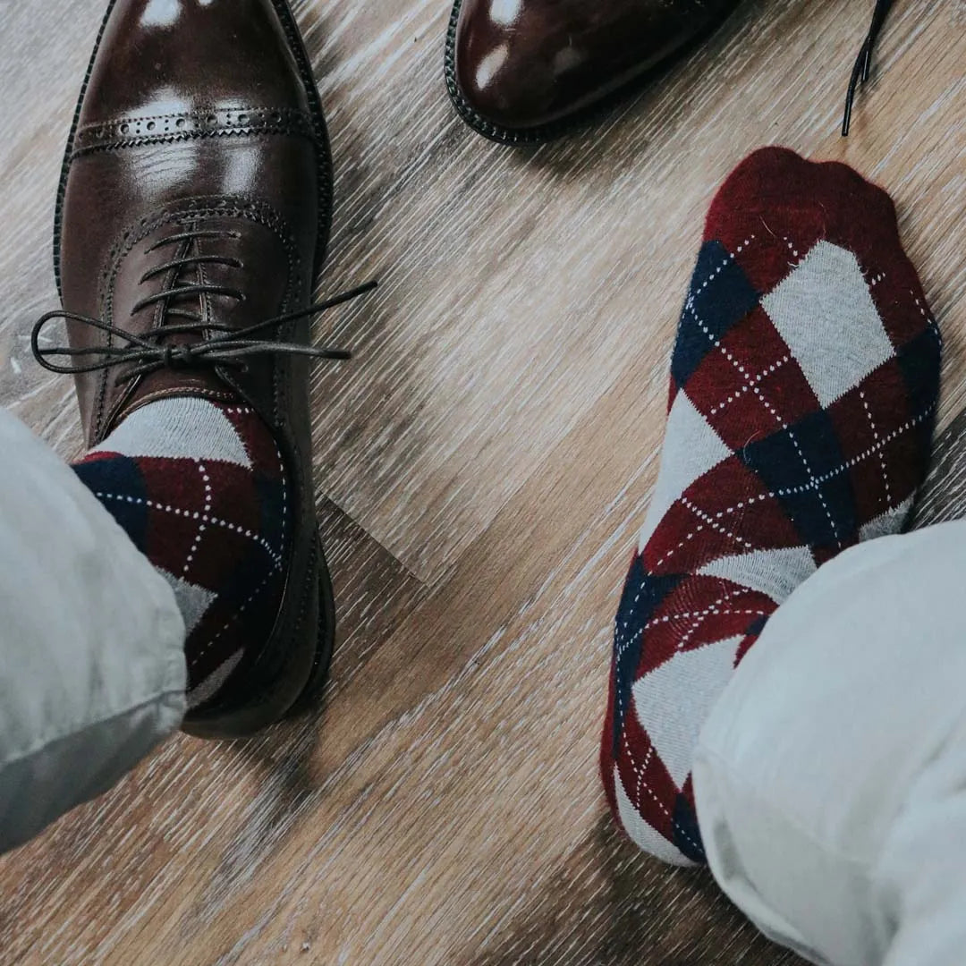 man wearing grey, red, and blue argyle socks