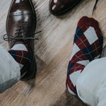 man wearing grey, red, and blue argyle socks