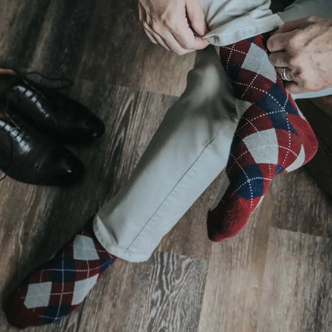 man wearing grey, red, and blue argyle socks