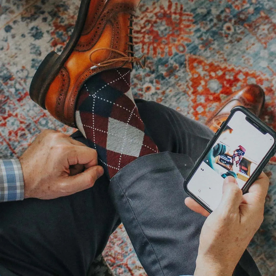 man wearing grey, red, and blue argyle socks