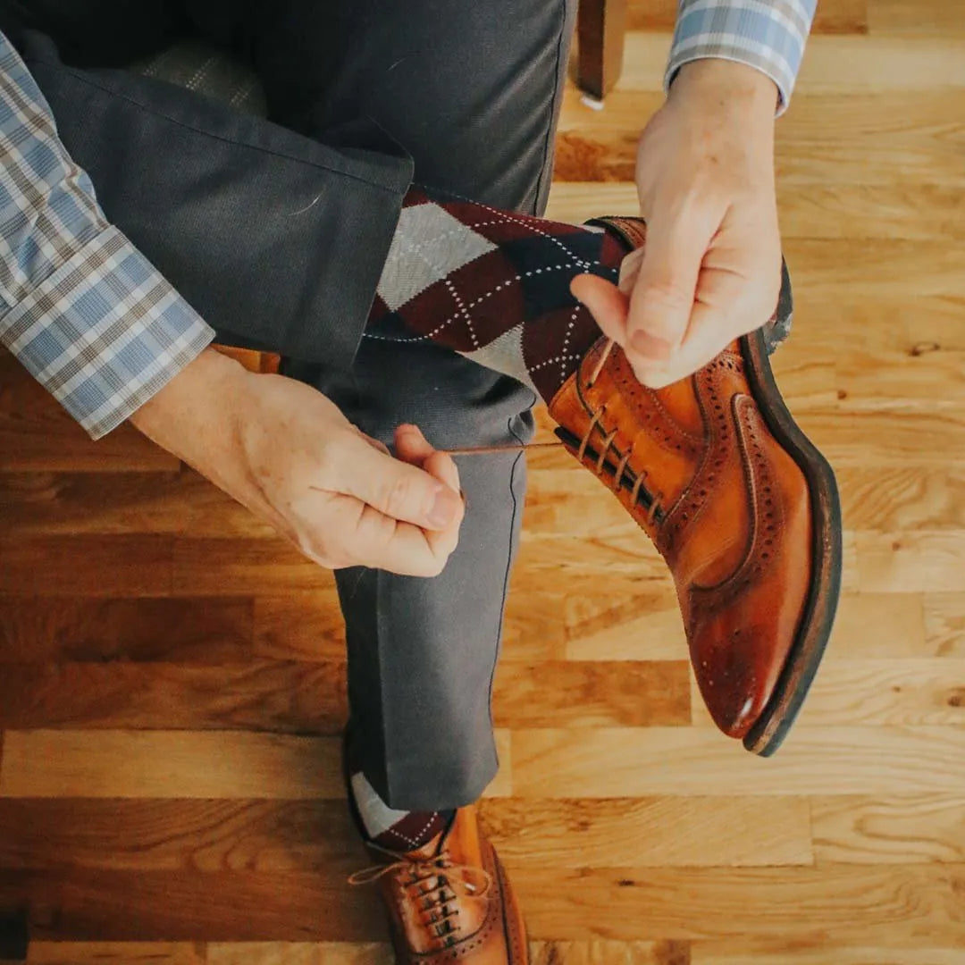 man wearing grey, red, and blue argyle socks