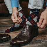 man wearing grey, red, and blue argyle socks