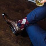 man wearing grey, red, and blue argyle socks