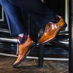 man wearing grey, red, and blue argyle socks