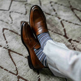 a man wearing grey, blue, and white striped men's dress sock