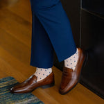 a tan men's dress sock with navy blue squares