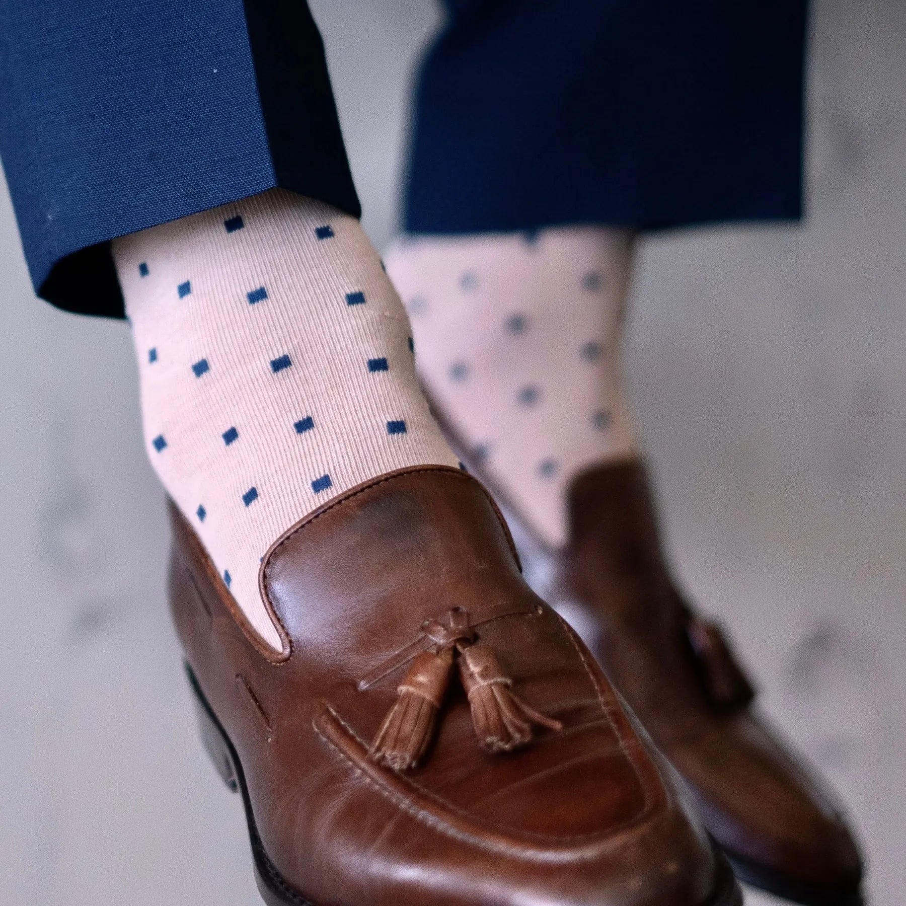 a tan men's dress sock with navy blue squares 