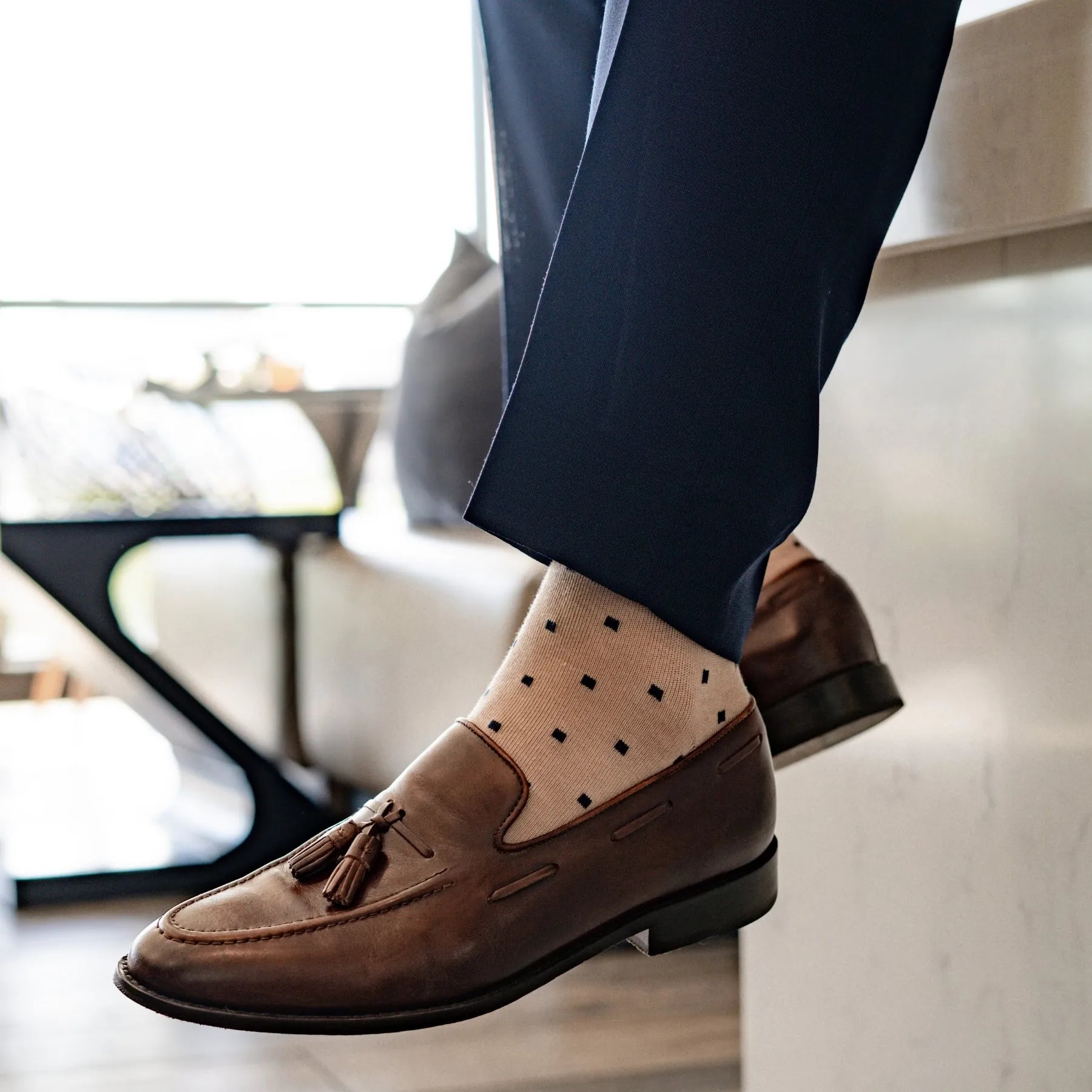 a tan men's dress sock with navy blue squares 