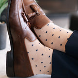 a tan men's dress sock with navy blue squares 