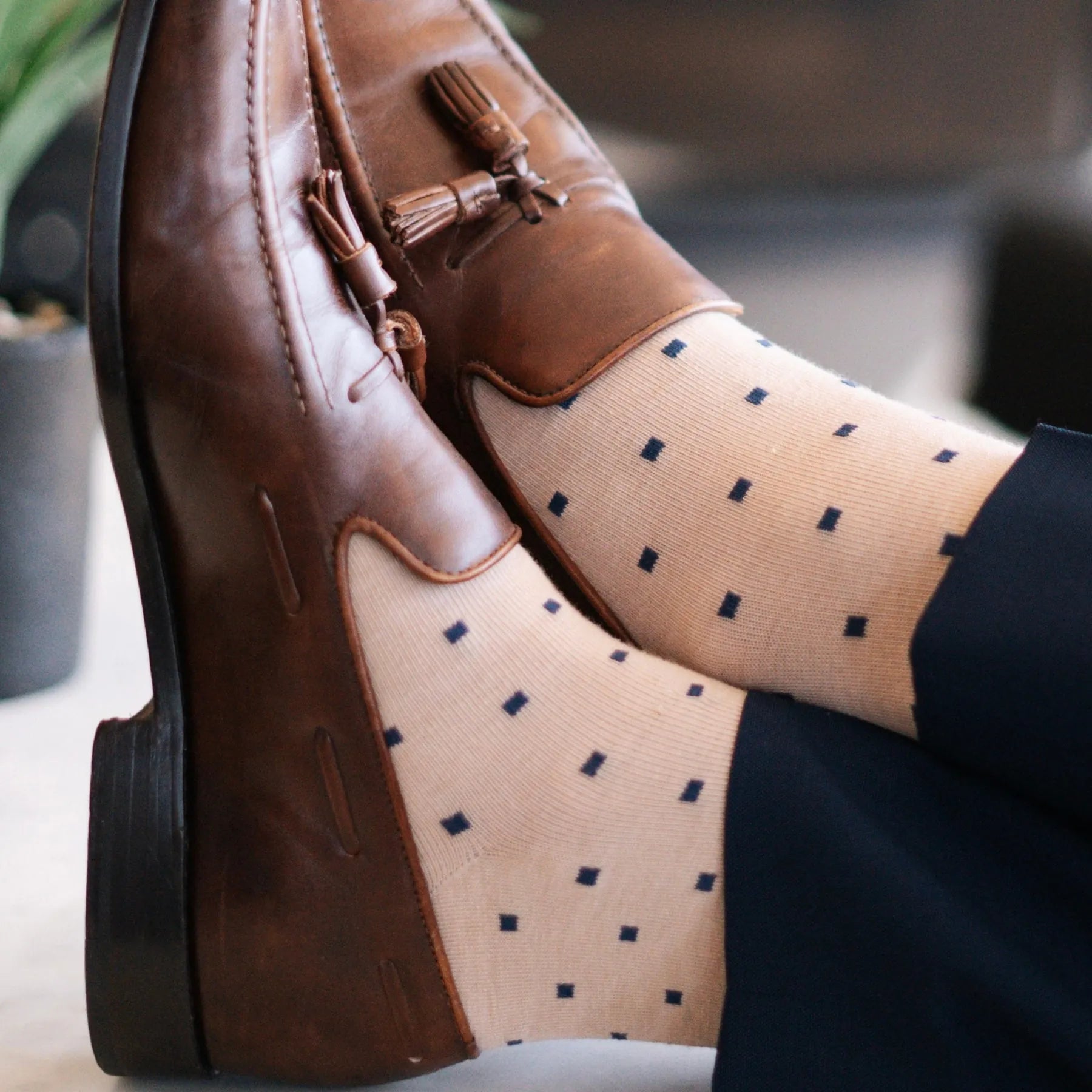 a tan men's dress sock with navy blue squares 