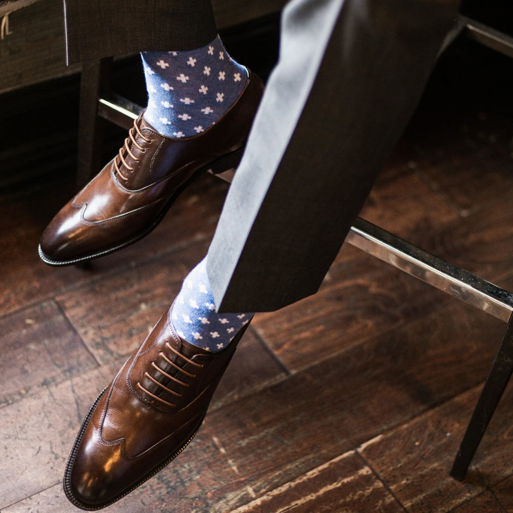 guy wearing grey slacks, blue socks, and brown shoes