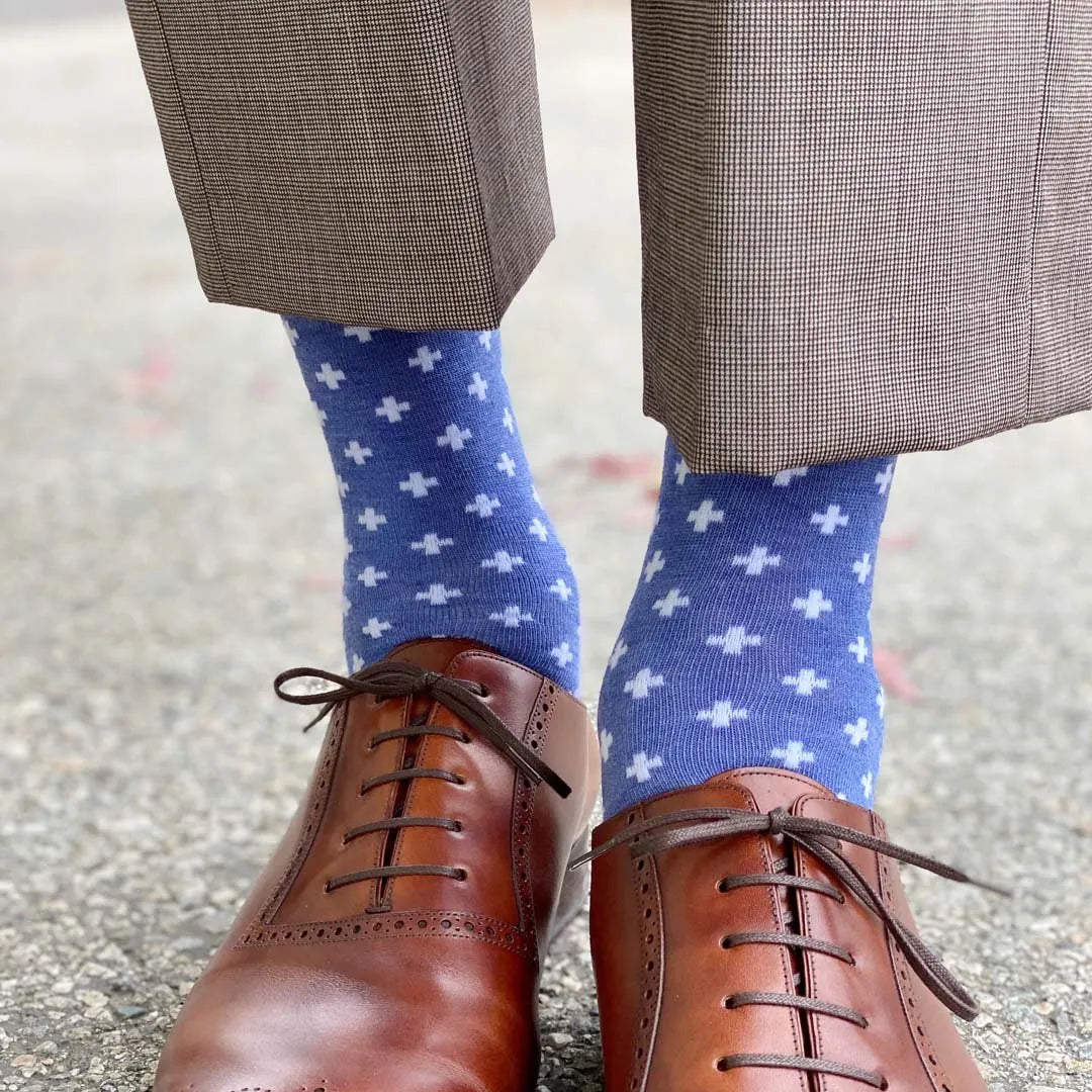 Man standing wearing heathered blue socks with white hatches and dress shoes