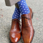 Man wearing heathered blue socks with white hatches and dress shoes