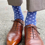 Man wearing heathered blue socks with white hatches and dress shoes