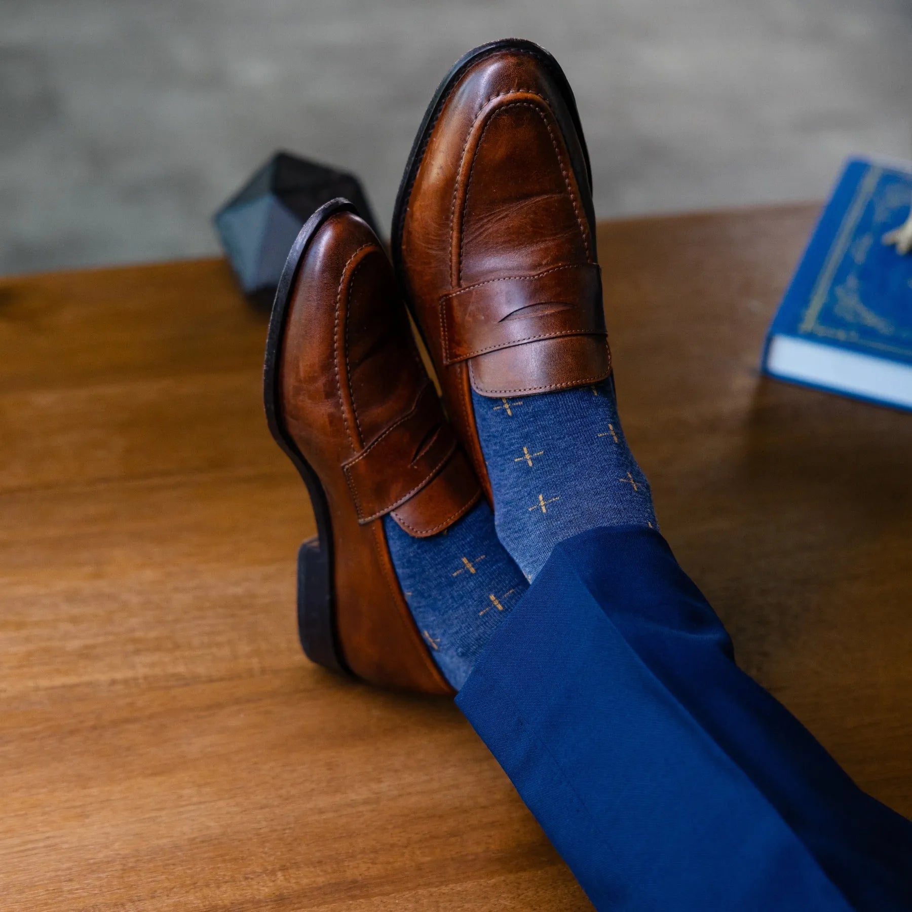 a deep blue sock with gold a gold t-sun pattern