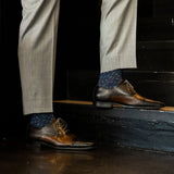 A dark blue men's dress sock with a light blue sprinkle pattern
