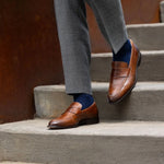 Man wearing blue socks with grey pants