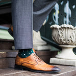 guy wearing grey slacks, green socks, with tan dress shoes