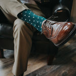 Man wearing green socks with white micro-squares and dress shoes