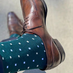 Man wearing green socks with white micro-squares and dress shoes