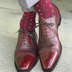 Man wearing cranberry socks with red and powder blue micro-squares