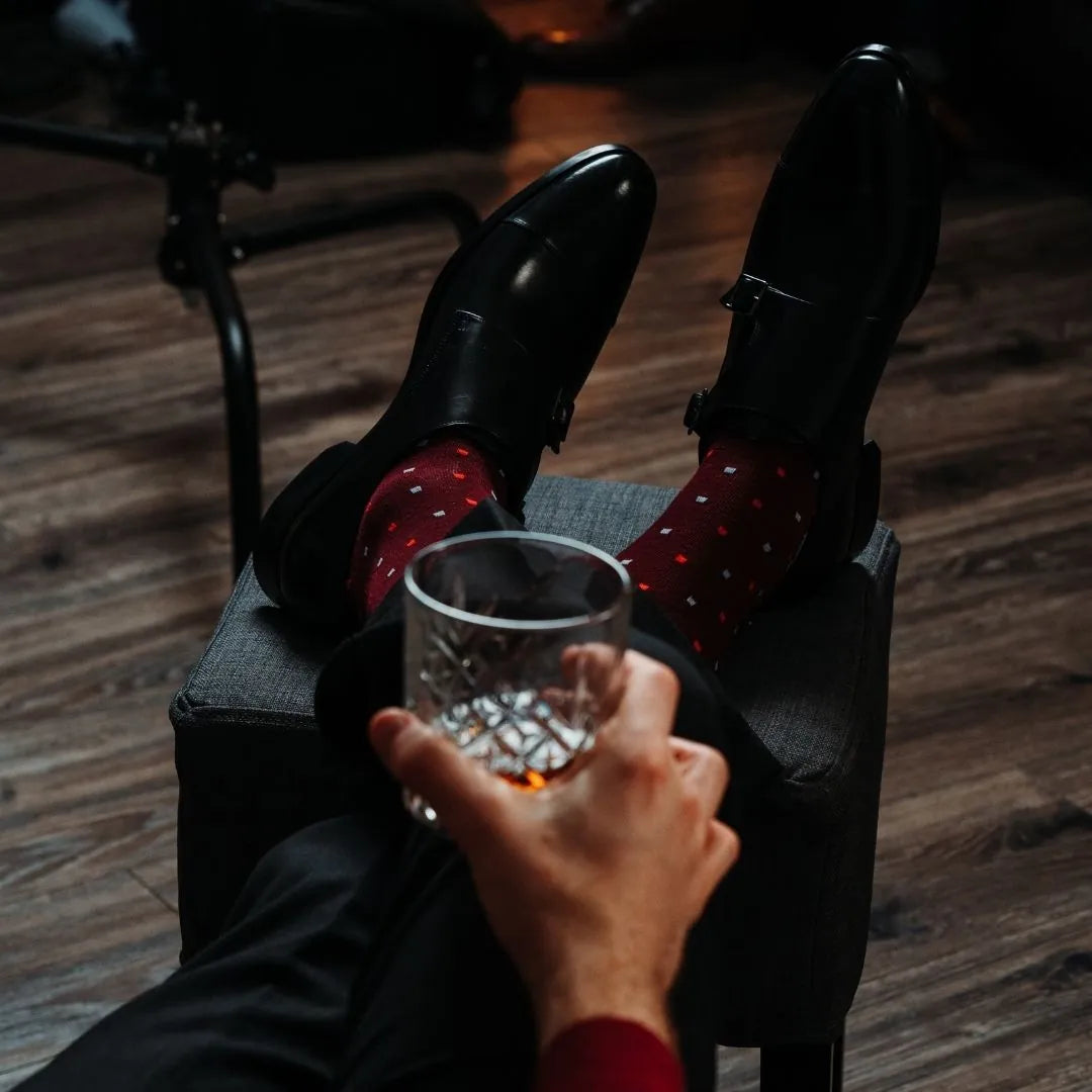 Man wearing cranberry socks with red and powder blue micro-squares