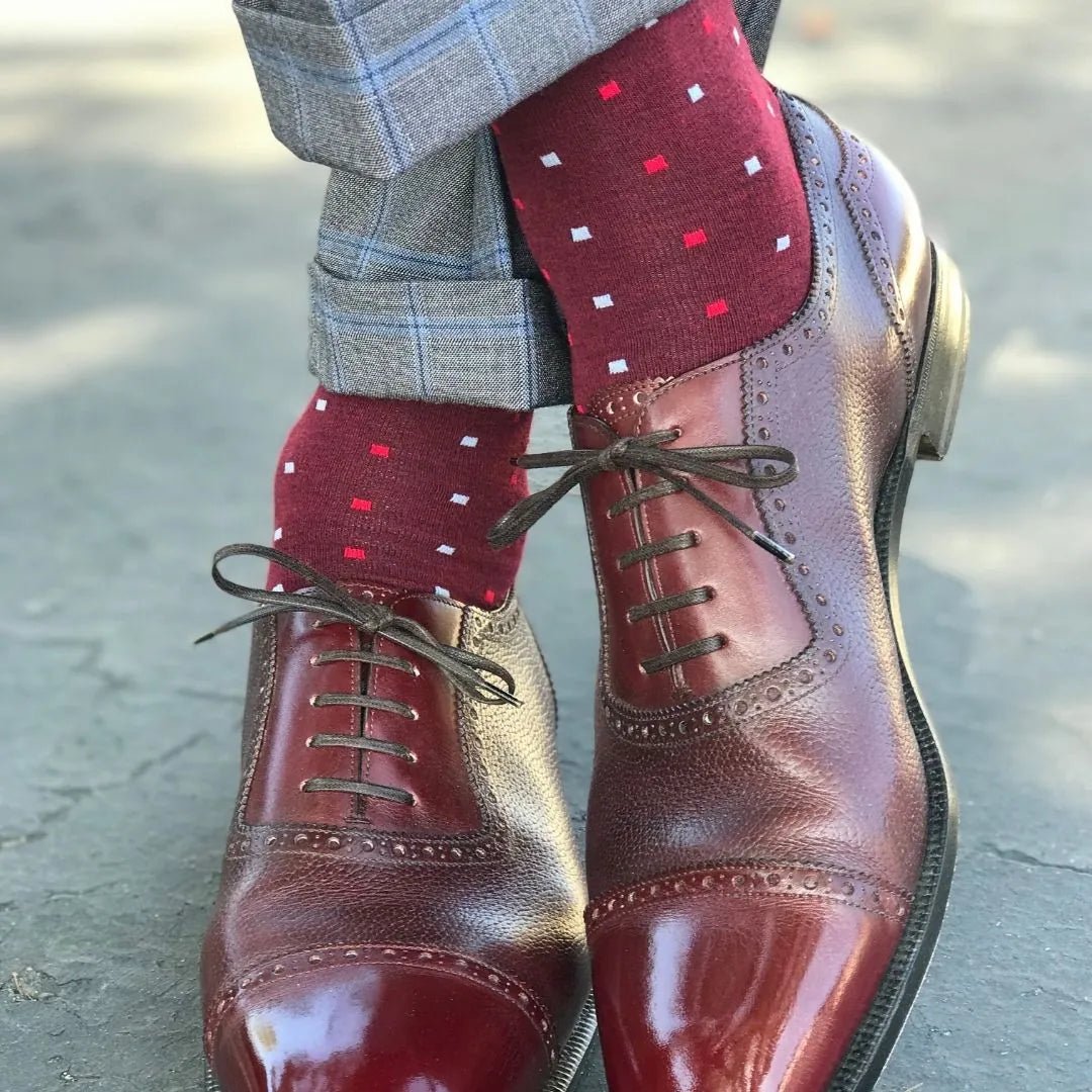Man wearing cranberry socks with red and powder blue micro-squares