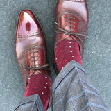 Man wearing cranberry socks with red and powder blue micro-squares