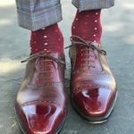 Man wearing cranberry socks with red and powder blue micro-squares