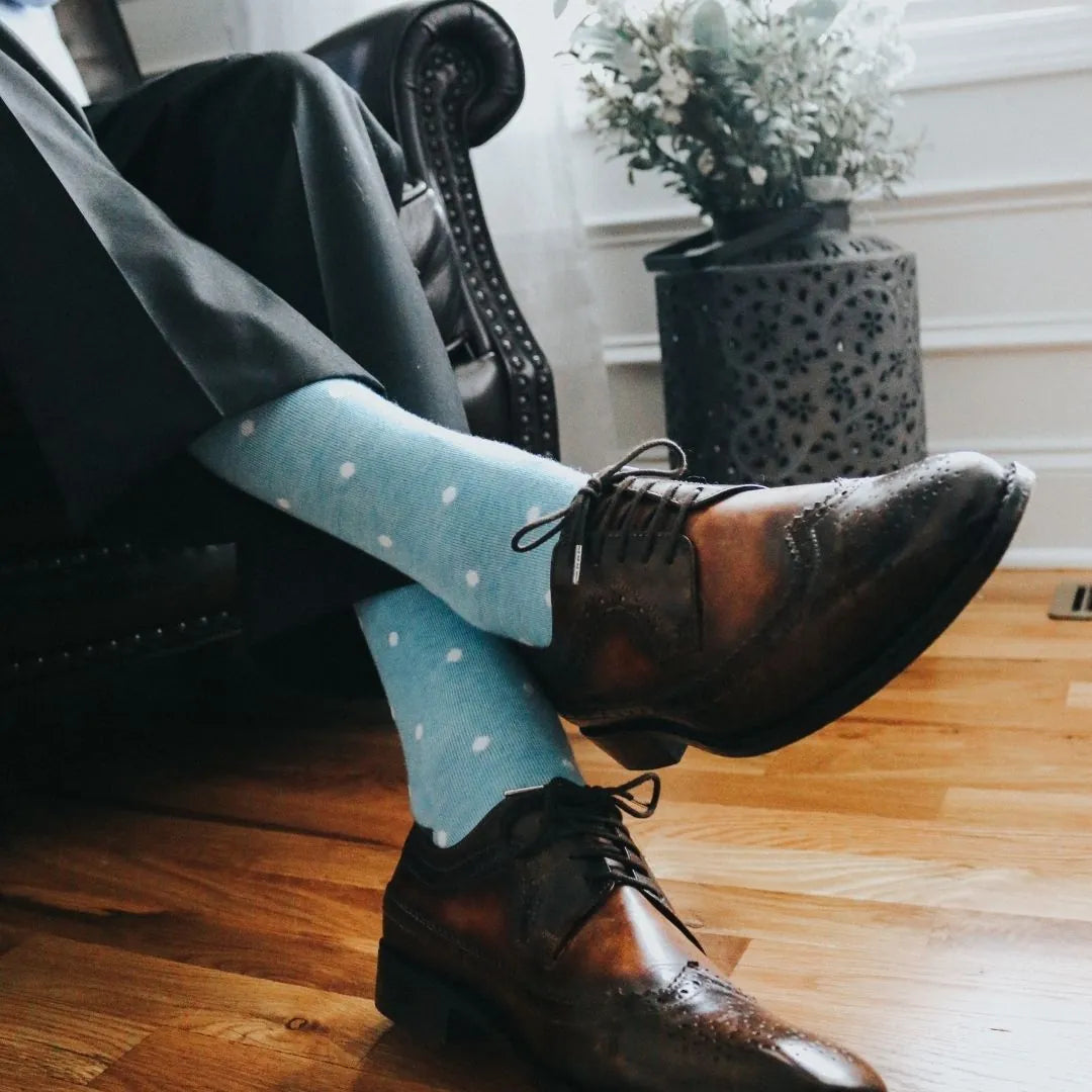 Man wearing baby blue and white polka dot socks, and dress shoes.
