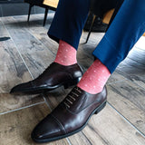 man wearing blue slacks and pink dress socks