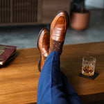 Rich chocolate brown men's dress socks with clean white accents, paired with navy trousers and brown leather loafers