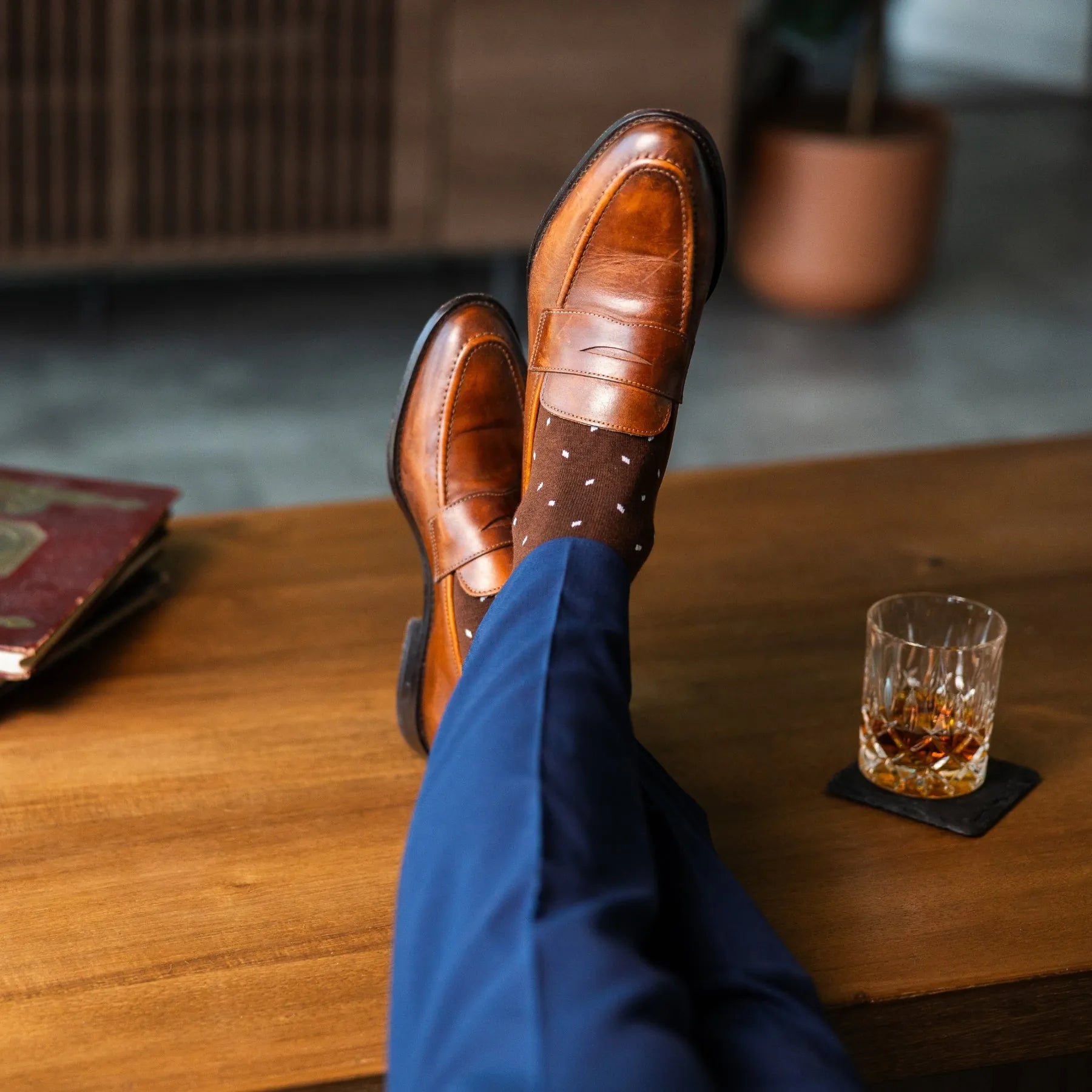 Rich chocolate brown men's dress socks with clean white accents, paired with navy trousers and brown leather loafers